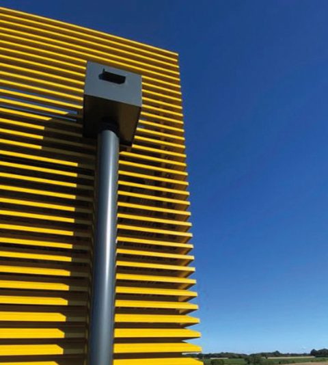Descente d'eau pluviale intégrée à un brise-soleil jaune