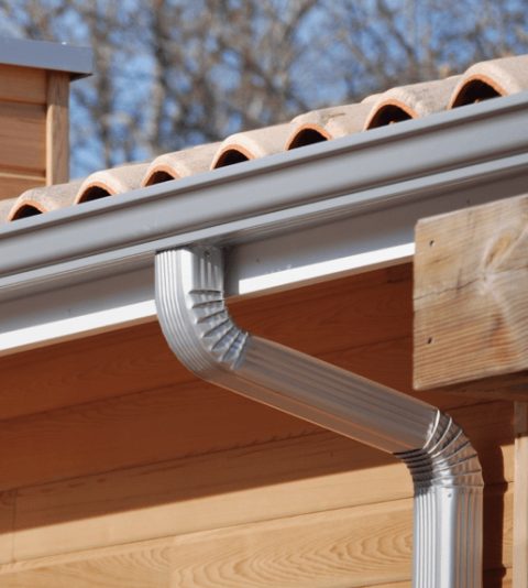 Gouttière et descente aluminium sur toiture en tuiles