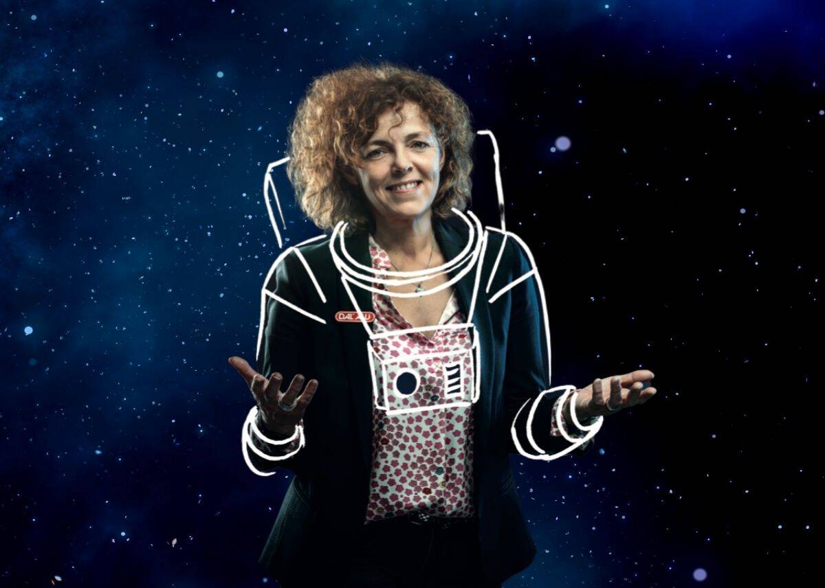 Femme souriante avec un appareil photo dans un espace étoilé.